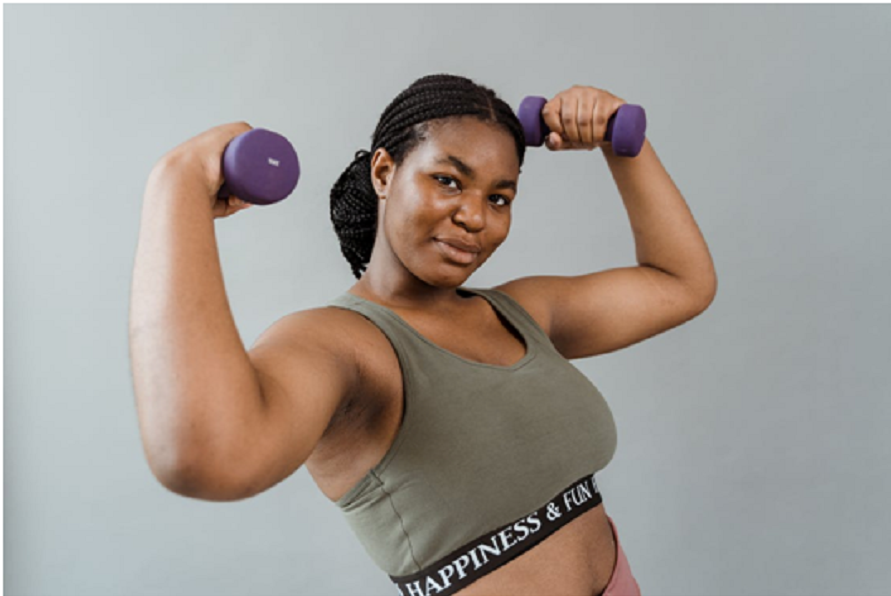 A trainer posing with dumbbells